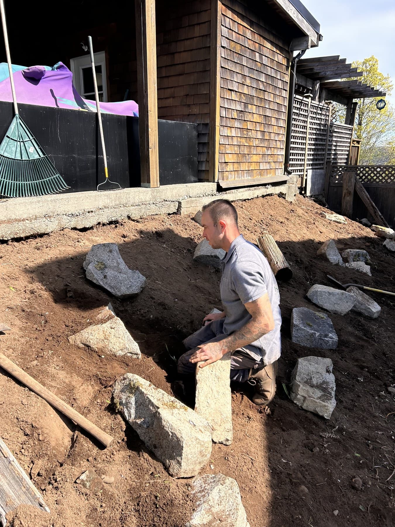 Tori shaping stones into a garden edge during installation
