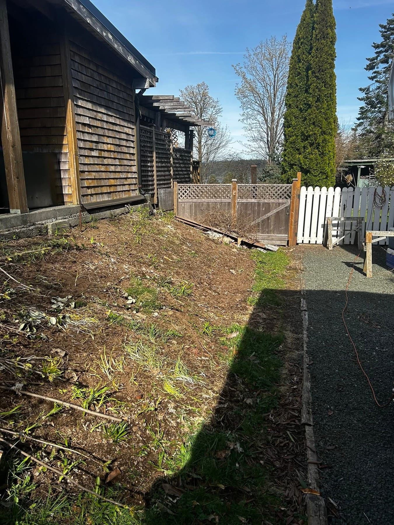 Side yard before installation with bare gravel path